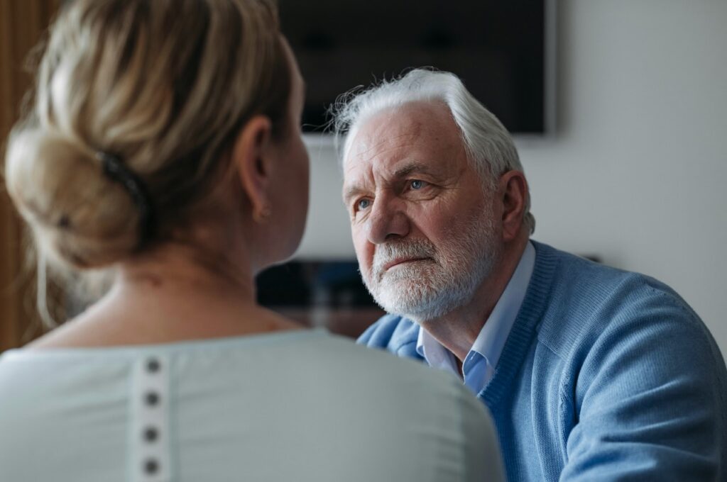 Older man speaking with a female therapist during a grief counseling session in a Monmouth County, New Jersey mental health office.