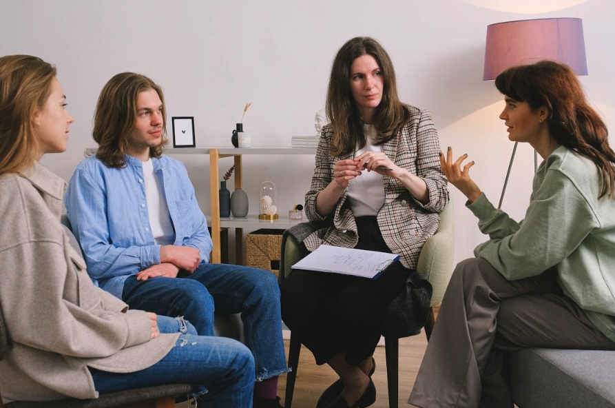 Small grief support group meeting with a therapist facilitating discussion among adults in an Ocean County, New Jersey counseling office.