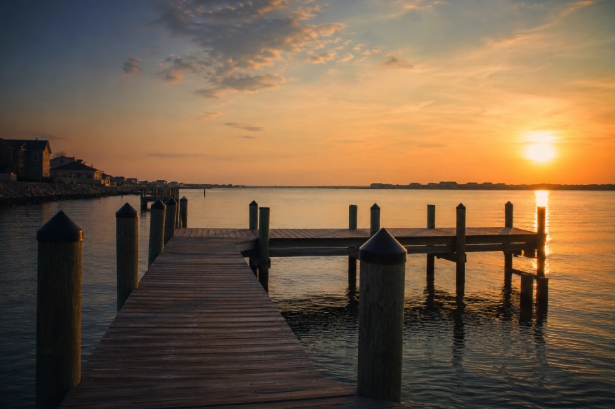 Quiet wooden dock over calm ocean water at golden hour along the New Jersey Shore
